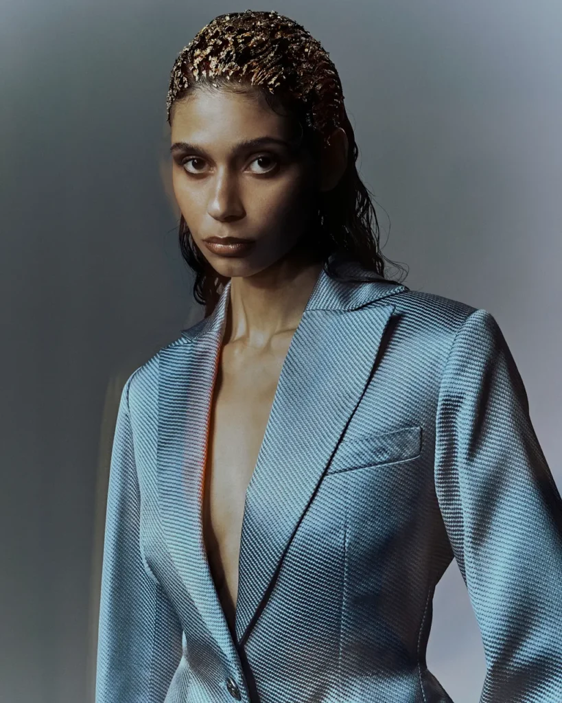 Portfolio Lorenzo Berni_084 - Lorenzo Berni Portrait of a woman in a metallic light-blue blazer with a deep V, looking at the camera with a neutral expression.