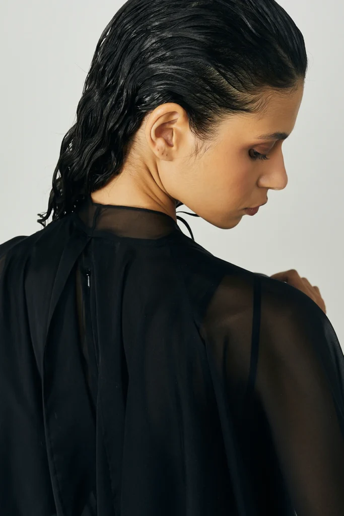 Portfolio Lorenzo Berni_097 - Lorenzo Berni Woman with slicked-back wet hair in a sheer black blouse, shown from the side.